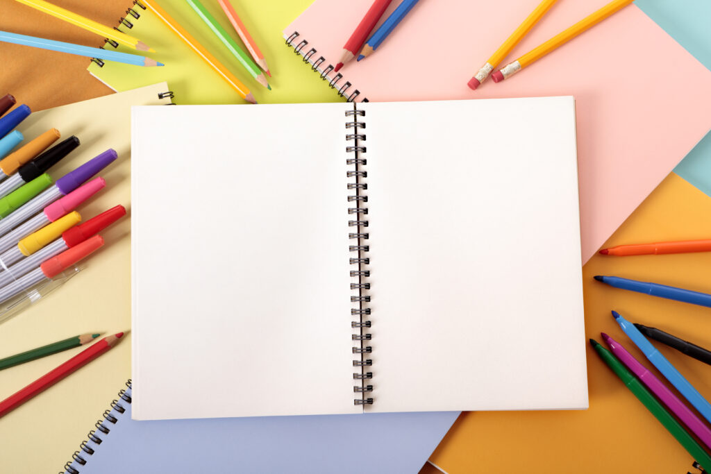 empty notebook with pencils and markers